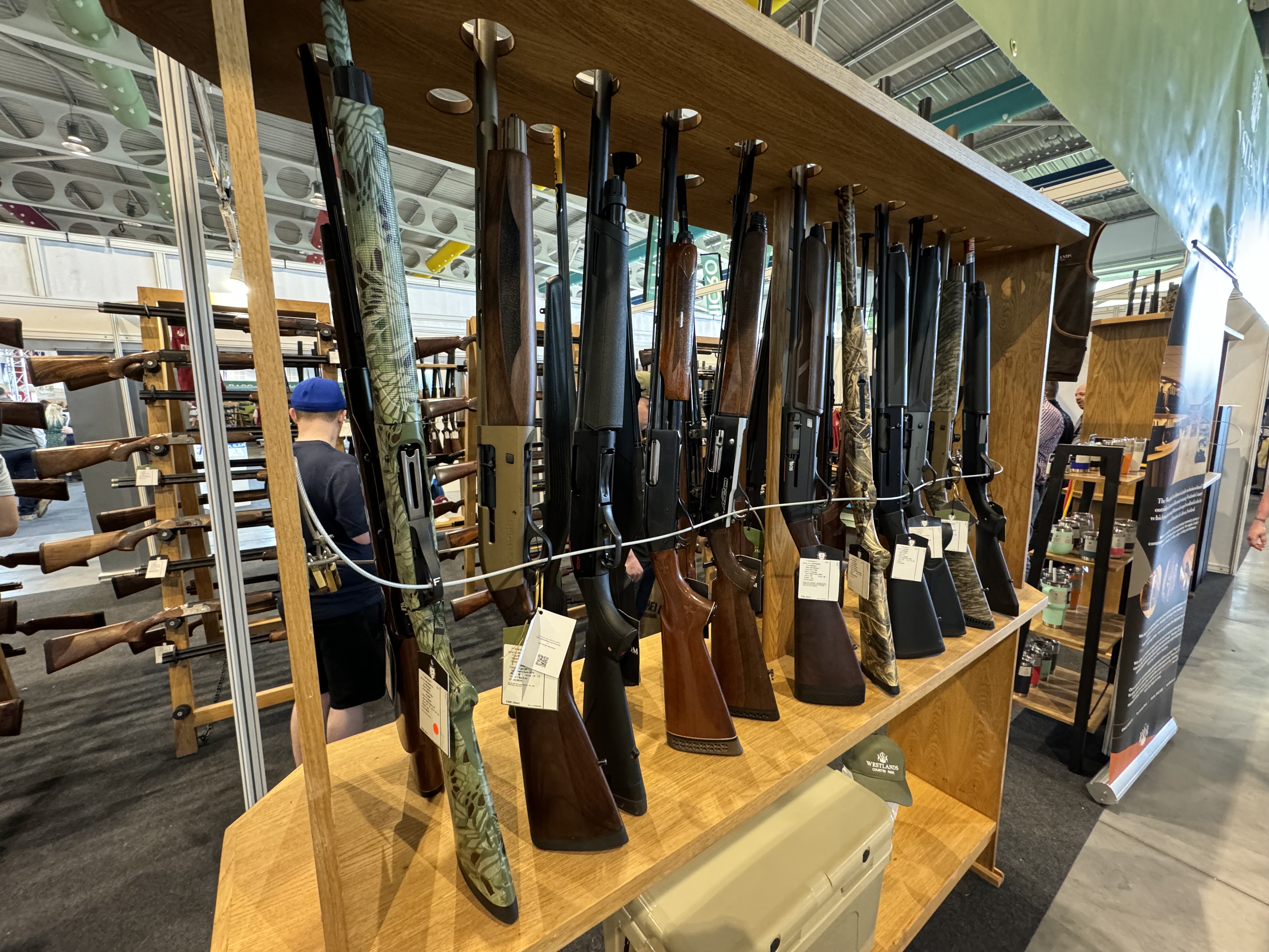 Shotguns displayed for sale at a real gun show vendor table
